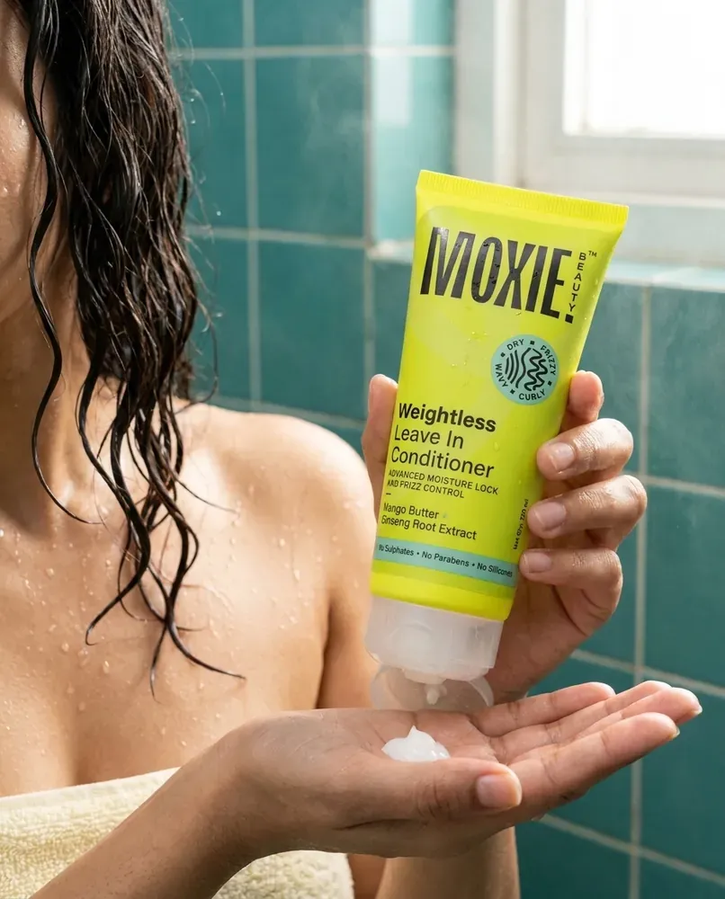A hand squeezing conditioner in the shower